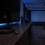 Aufgerolltes HDMI-Kabel vor dunklem Fernseher und Beamer im Heimkino (KI-generiert)