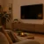 Gemütliches Wohnzimmer mit wandmontiertem Fernseher über einem Sideboard (KI-generiert)